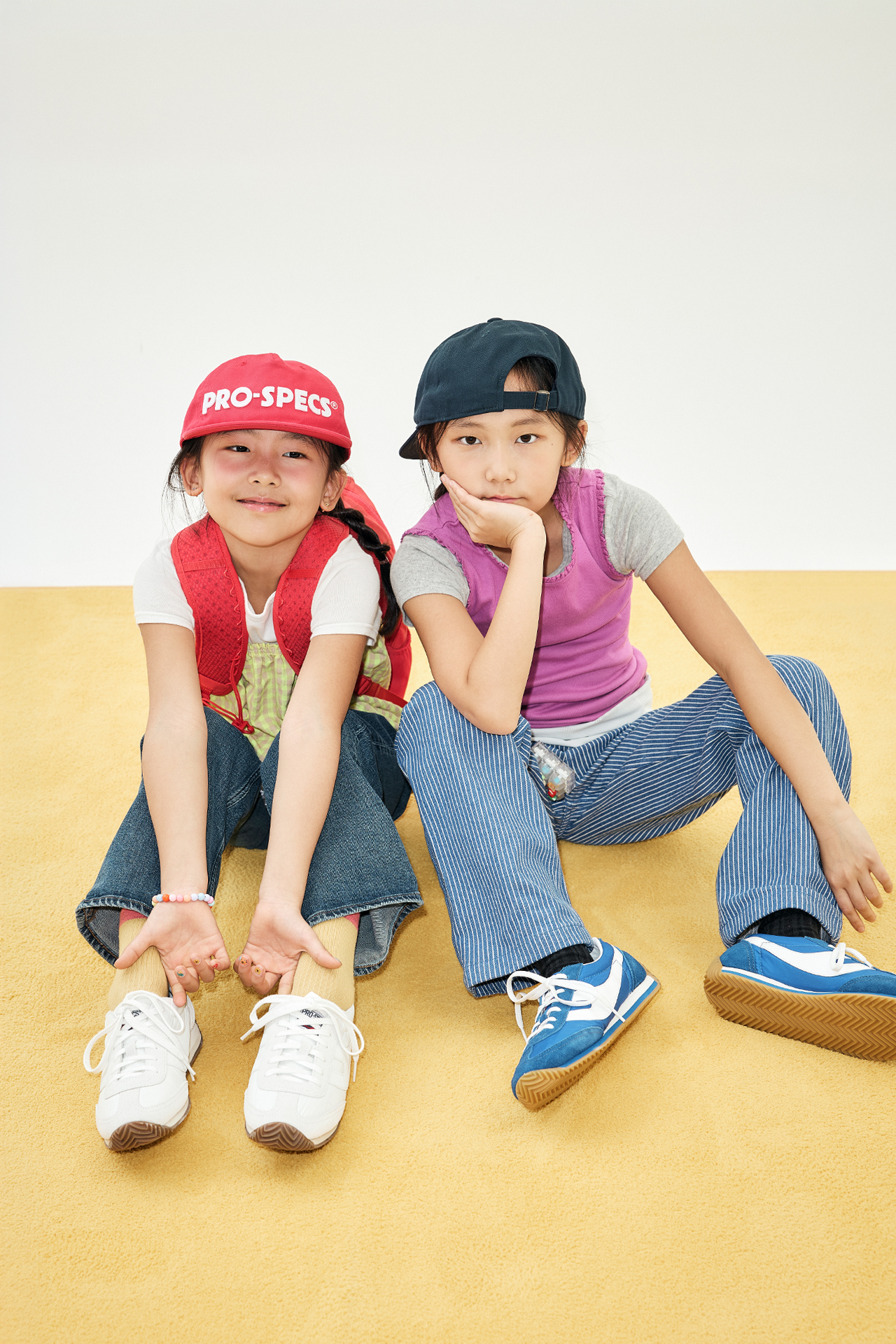 빨간 캡과 검은 캡을 쓰고 나란히 앉아있는 하울과 나우