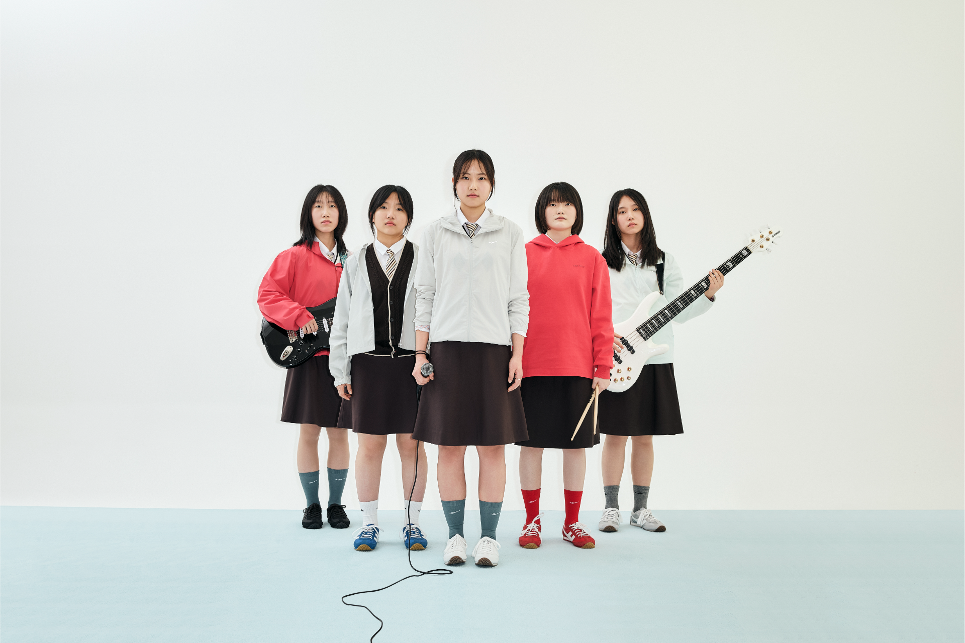 다섯 멤버가 나란히 서서 블랙, 블루, 화이트, 레드, 그레이의 마라톤 110을 신은 발 라인업