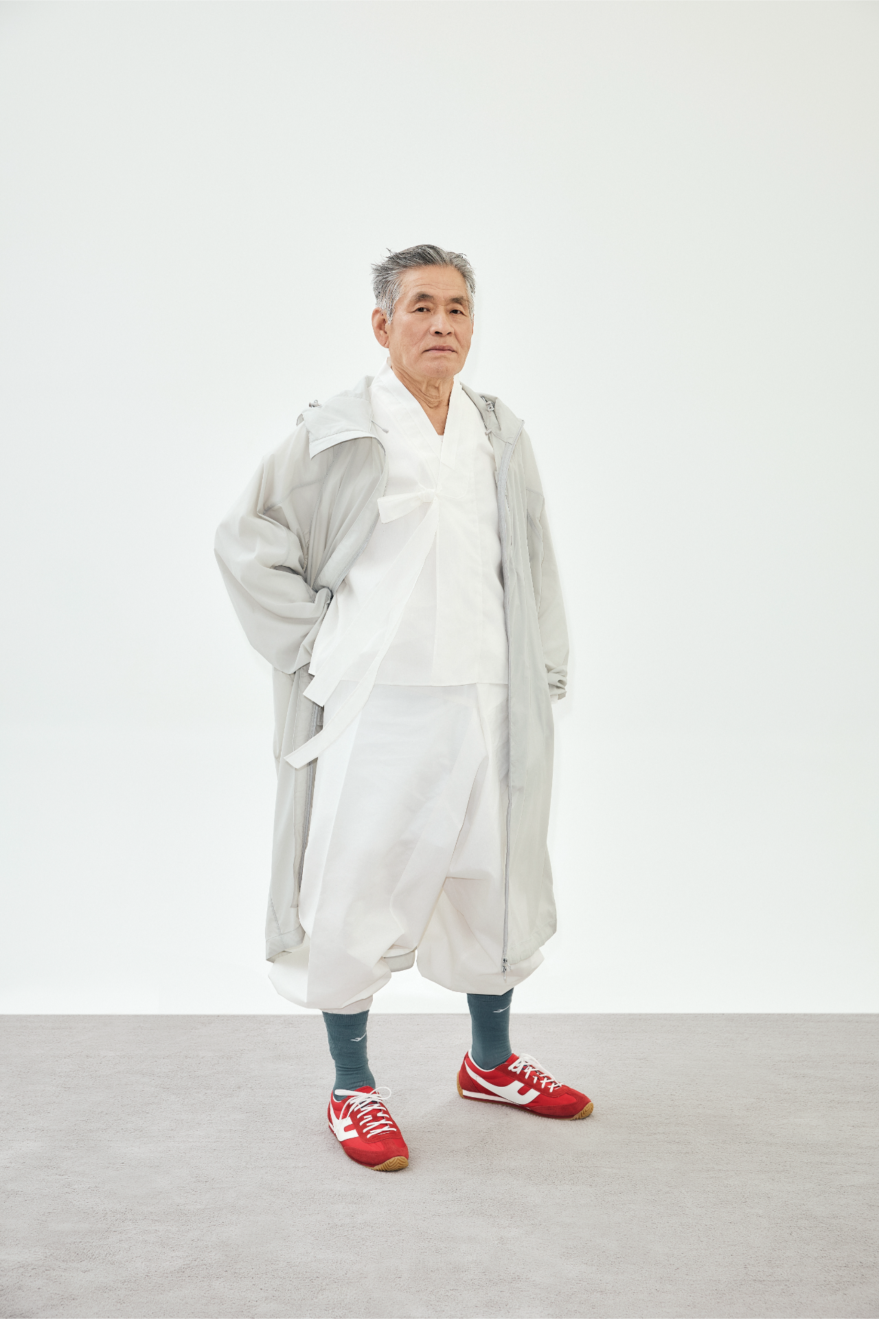 회색 후드 코트를 어깨에 걸친 김종수의 정면 컷
