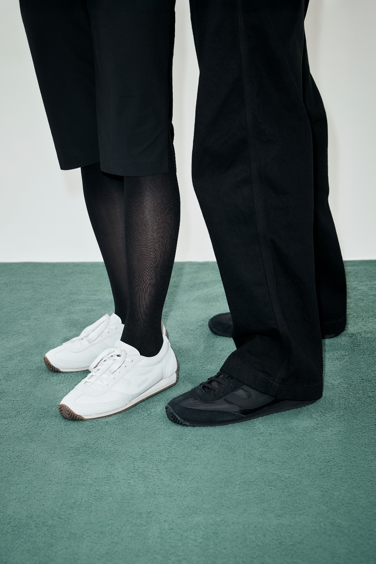 흰색과 검은색 마라톤 110 스니커즈를 신은 두 사람의 발 클로즈업